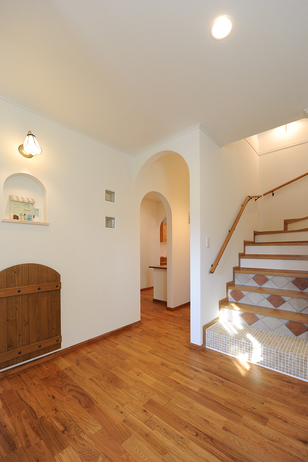 アイディートゥー 一級建築士事務所【デザイン住宅、輸入住宅、間取り】ゆったりとした玄関ホール。風合いのある床は無垢のオーク材。正面に進むとLDK、左に進むと水回りスペースに。スリッパ収納のよろい戸がアクセントに。裏側の洗面脱衣室が暗くならないよう、壁にガラスブロックを設置して光を通している