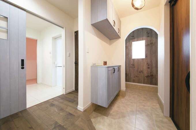 玄関も広々。アーチ型開口の奥は土間収納、写真左には洗面脱衣所がある