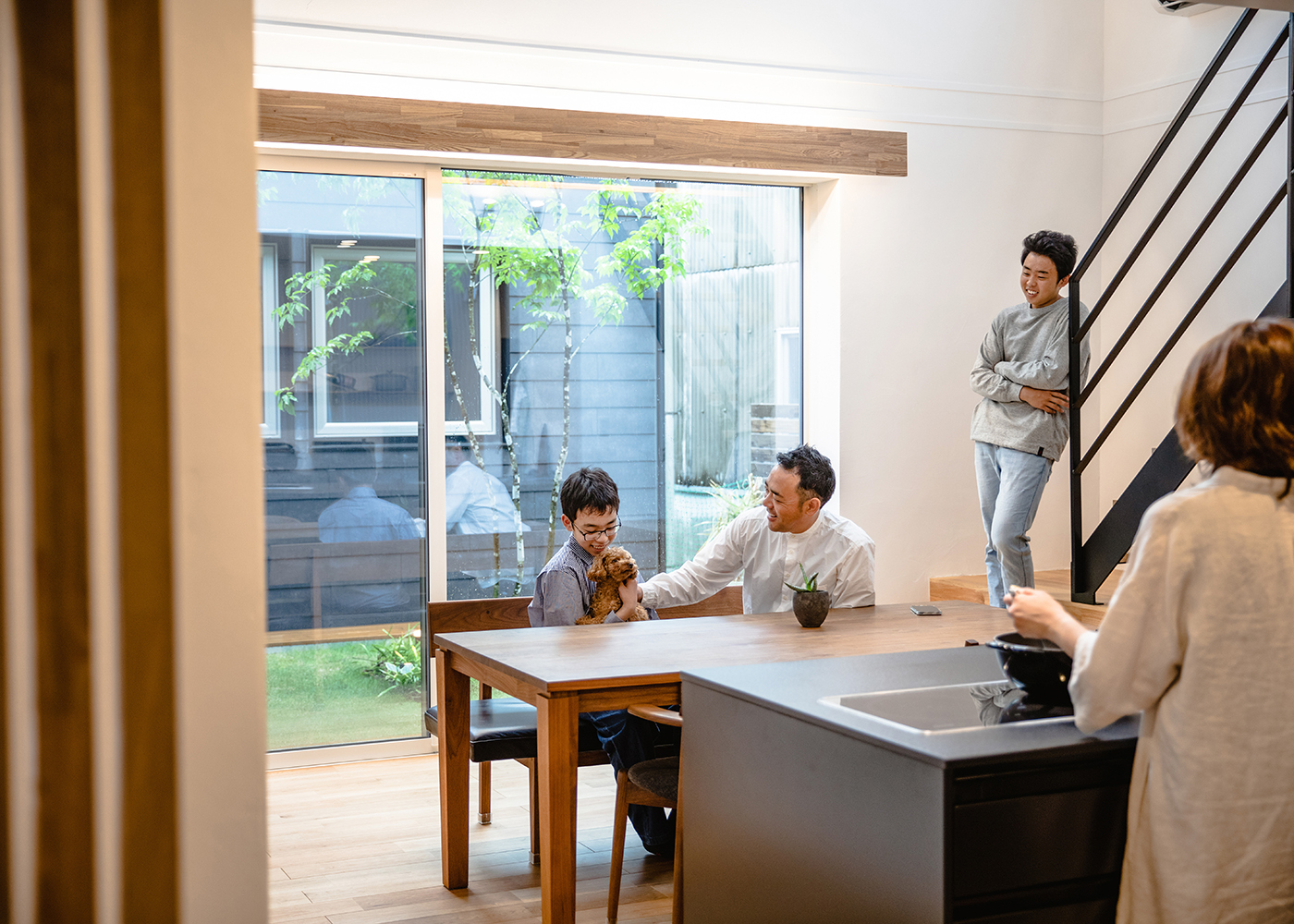 ainoa.life くらはし建築【デザイン住宅、間取り、インテリア】キッチンからの風景。大きな窓からたっぷりの自然光が差し込む。家族が集まりくつろぐのにぴったりの空間が広がっている