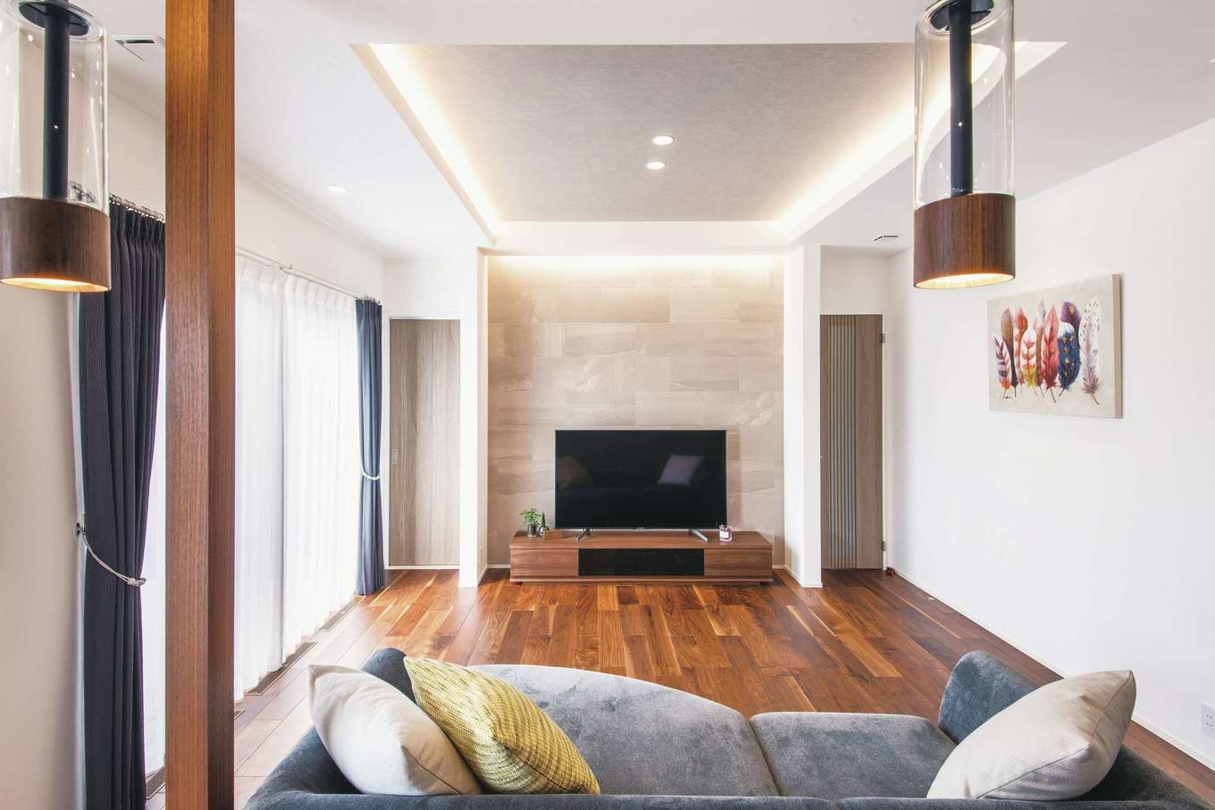 コットンハウス【デザイン住宅、子育て、省エネ】エコカラットのアクセントウォールと間接照明が映えるリビング。壁や建具は奥さまの好きなニュアンスカラーでコーディネート。天井高は270cmよりもさらに高くして縦の広がりを強調した