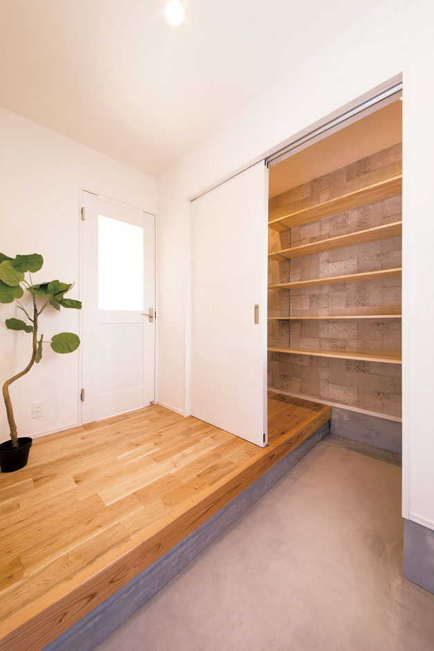 住たくeco工房【1000万円台、デザイン住宅、自然素材】玄関のたたきはコンクリート打ち放し。造り付けの土間収納が標準設備としてついている。壁はコンクリート調クロスでテイストを合わせて