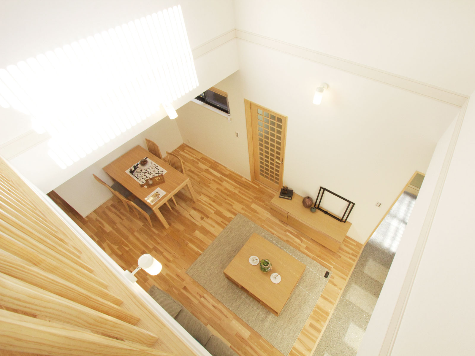 ヘスタホーム｜開放感ある吹き抜けのリビング。ナチュラルな木材が温かみを感じさせ、心地よい空間が広がる。