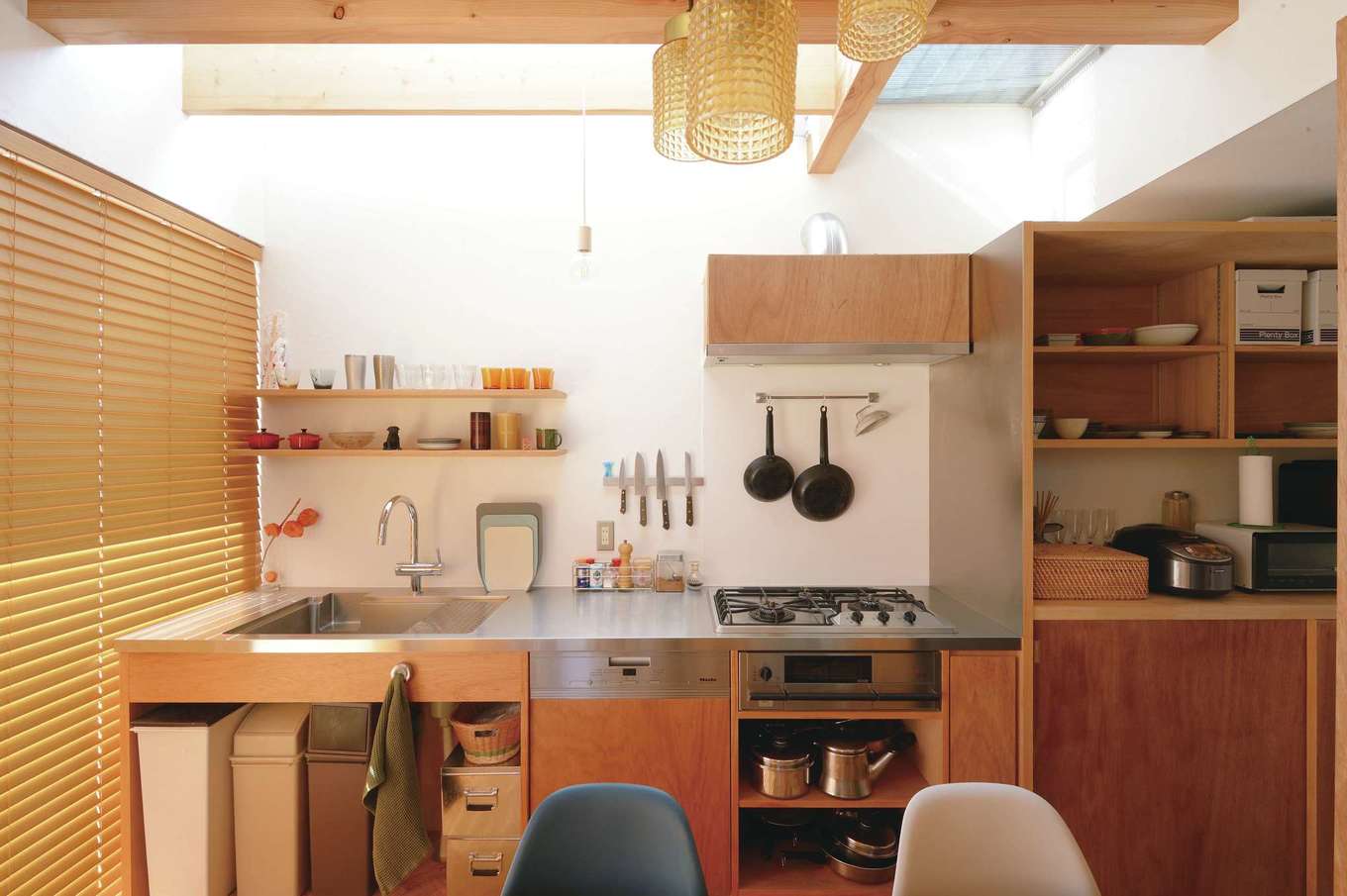 MABUCHI【デザイン住宅、狭小住宅、間取り】ラワン材で仕上げたオーダーメイド・キッチン。オープンラックを壁に設け、「見せる収納」を上手にとり入れている。キッチン部分も吹抜けになっているため、大きな高窓から光が注ぎ、清々しい気分で調理ができる