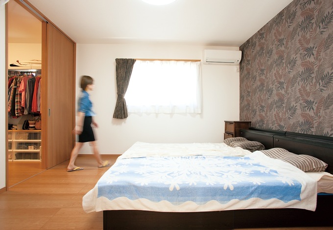 2階のメインベッドルームは、敢えて南側に窓をつけず、代わりにシックな花柄のアクセントウォールで落ち着いた空間にした。納戸も併設
