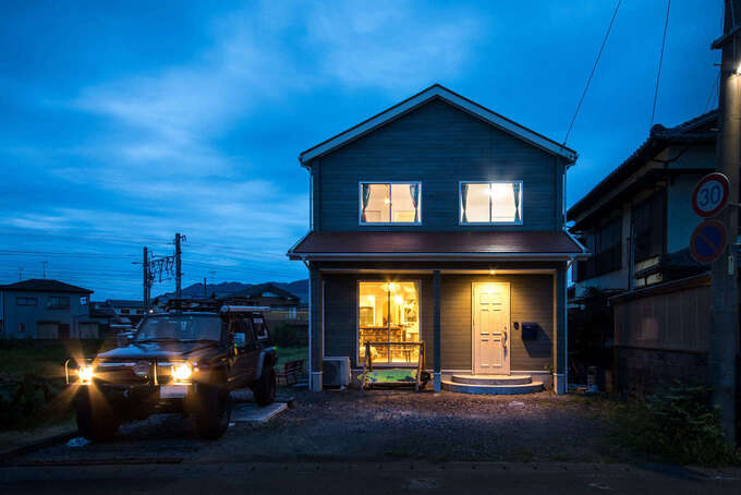 三角屋根のフォルムが夕景に映える外観。半円形の玄関ポーチが建物の雰囲気とぴったり！庭や駐車場はこれからご主人が手を入れる予定