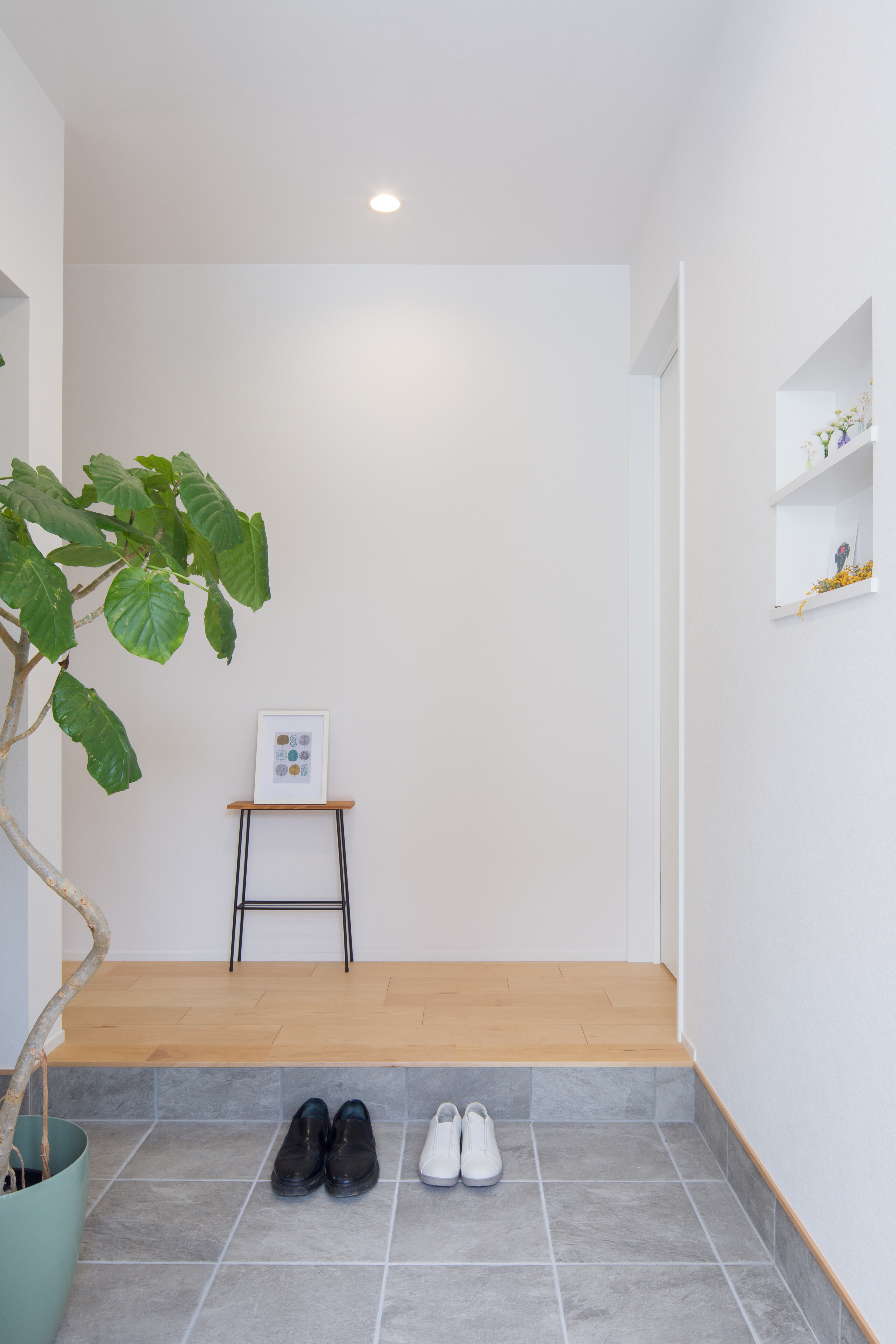 シンプル｜玄関は正面に扉を配置しないことで、線を少なくし、シンプルに仕上げました。
写真や小さな小物を飾ることのできるニッチは、Ｓ様のこだわり。