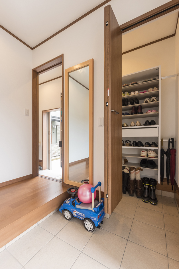 興友ハウス【子育て、収納力、間取り】玄関には土間収納を。奥の扉は駐車場へと続いている