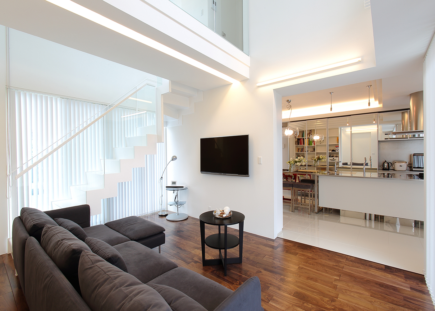 丸昇彦坂建設【デザイン住宅、間取り、ガレージ】扉で仕切らず開放感あふれるLDKは、大きな窓からの採光やこだわりの照明の光で上品な空間に。床のクロスで空間を区切ってメリハリをつけている