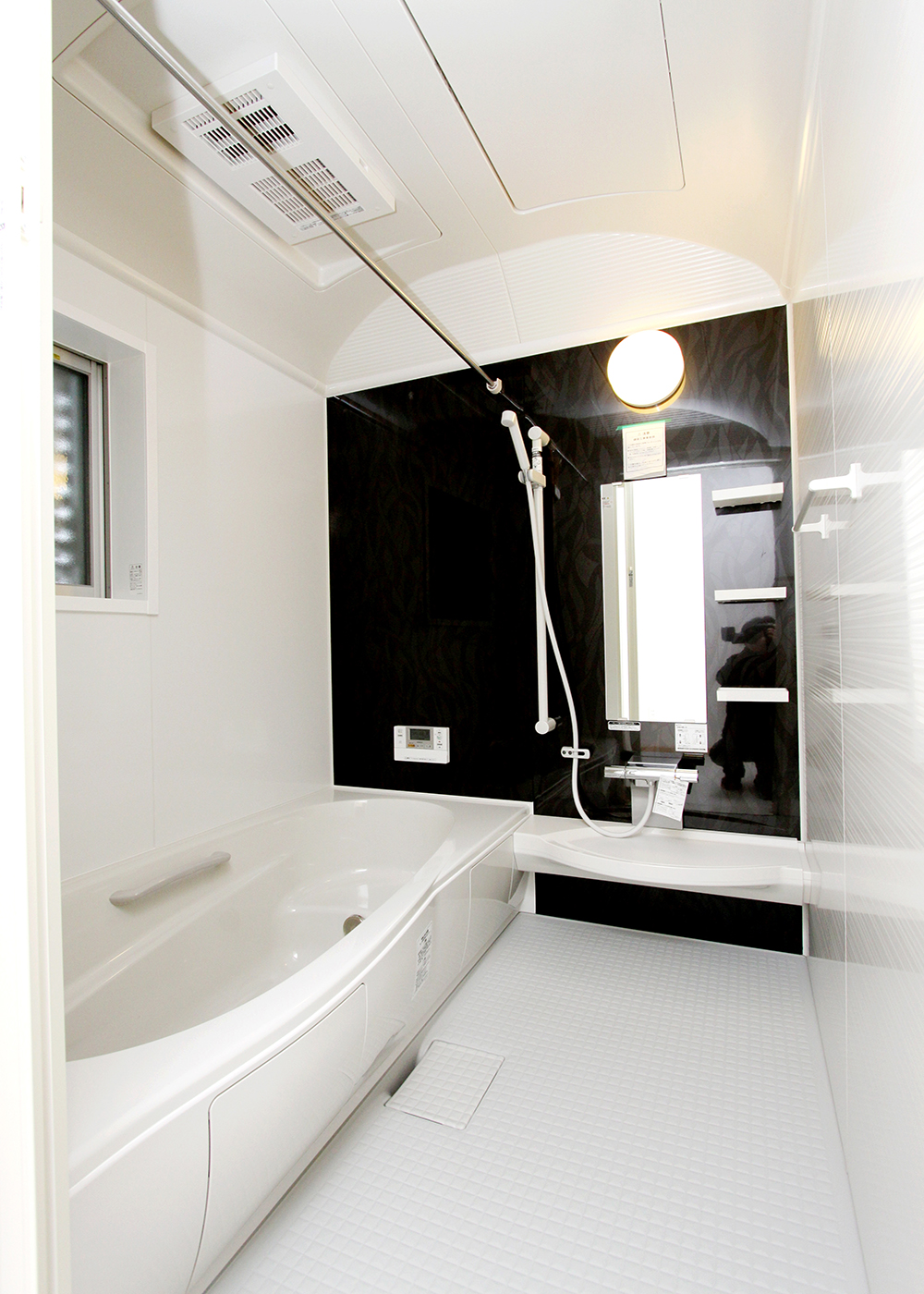 丸昇彦坂建設【デザイン住宅、間取り、インテリア】白で囲われたUBは、重厚な黒いアクセントパネルで高級感を引き立てる。パネル1つでここまで印象が変わる