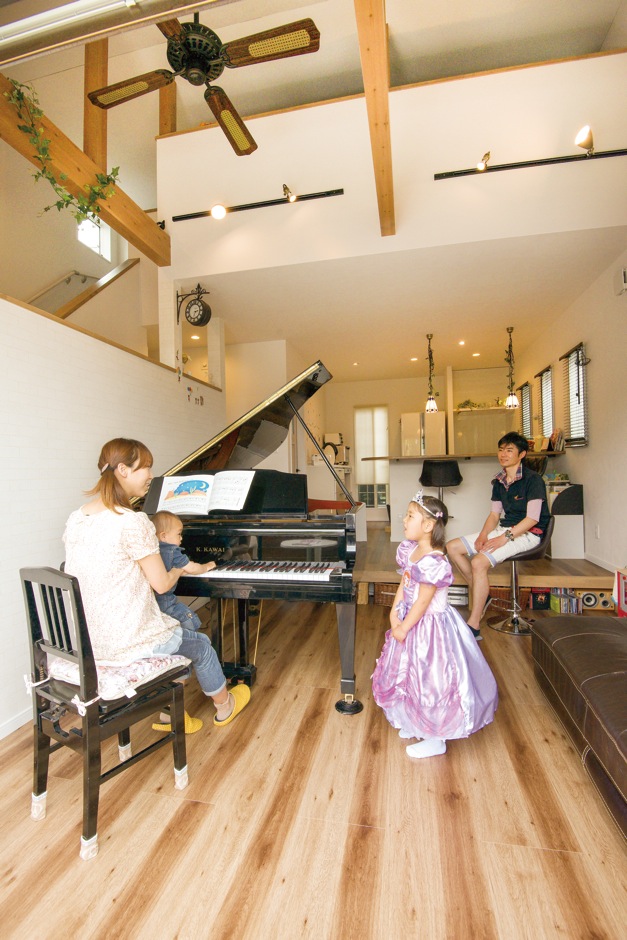 三和建設【子育て、趣味、スキップフロア】グランドピアノを家族が集まるリビングに置きたいという希望を叶えるため、段差のある多層構造と補強工事で、眺めを犠牲にすることなく、ピアノを中心にした空間を作り上げた。ベランダへつながる大きな窓と吹抜け空間のおかげで、開放感も味わえる居心地の良い部屋となった