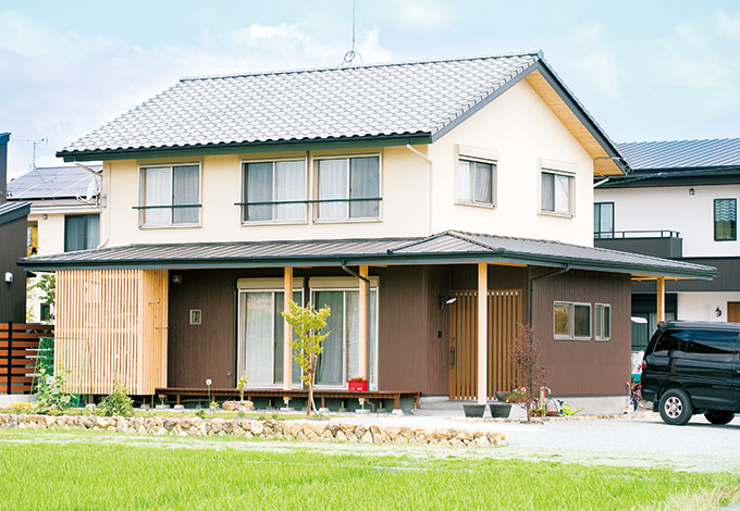 福工房【子育て、自然素材、間取り】田んぼを目の前に、安心感あるたたずまいを見せる。「この風景に似合うと思って」と瓦を選択