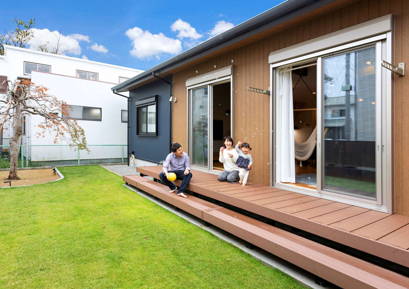 Yamaguchi Design 【省エネ、間取り、平屋】南側に芝生の庭と憧れのウッドデッキを設け、BBQや子どもプールを存分に楽しむ。祖母の代から植わっていた紅葉のシンボルツリーが家族の成長をやさしく見守る