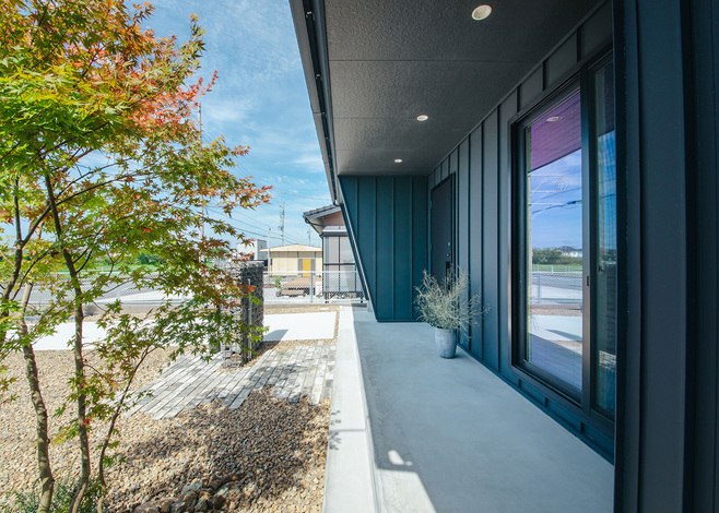 デッキ部分の軒を深く出し、夏場の暑い日射をコントロールできる形状に。植栽が外観のアクセントになっているだけでなく、外部からの視線を遮る効果も