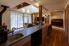 奥さまの夢を叶えたオリジナルの造作キッチン。ダークグレーの人工大理石の天板がママ友に大好評。吹抜けを通して2階の気配がわかるので、奥さまも安心して料理に集中できる