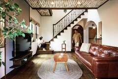 吹抜けの高窓から柔らかな光が差し込むリビング。折下げ天井を採用したことで視界が広がり、より開放感が生まれた。職人手づくりの木とアイアンの階段がインテリアの主役になっている。床は無垢のアンティークオーク。アルゴンガス入りの高性能ペアガラスを採用し、交通量の多い立地でもほとんど騒音が聞こえない