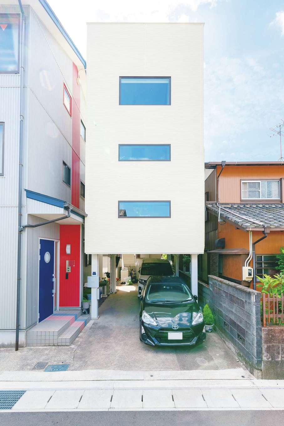 nattoku住宅｜実家の隣の狭小地に建つA邸。鉄骨のピロティをそのまま活かし、吹抜けの2階建てを提案した。コンパクトな外観と開放感のある室内とのギャップも面白い。外壁は耐久性、断熱性、防火性、遮音性に優れた37ミリ厚のALC（軽量気泡コンクリート）を標準で使用