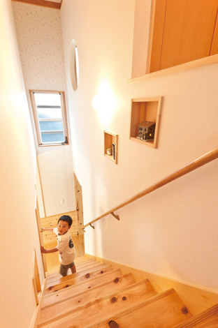 階段上部は吹き抜けにして。飾り棚にはライトアップもで きるK 邸の模型が