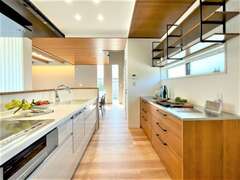 木のぬくもりを感じる空間に馴染むカップボードは、「見せる」収納。キッチンはタッチレス水栓を採用した