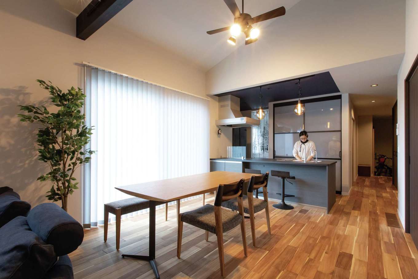 Yamaguchi Design 【自然素材、平屋、ガレージ】キッチンスペースは折上げ天井にして変化を付け、黒とグレーで統一。背面扉の奥にキッチン用品を隠して収納