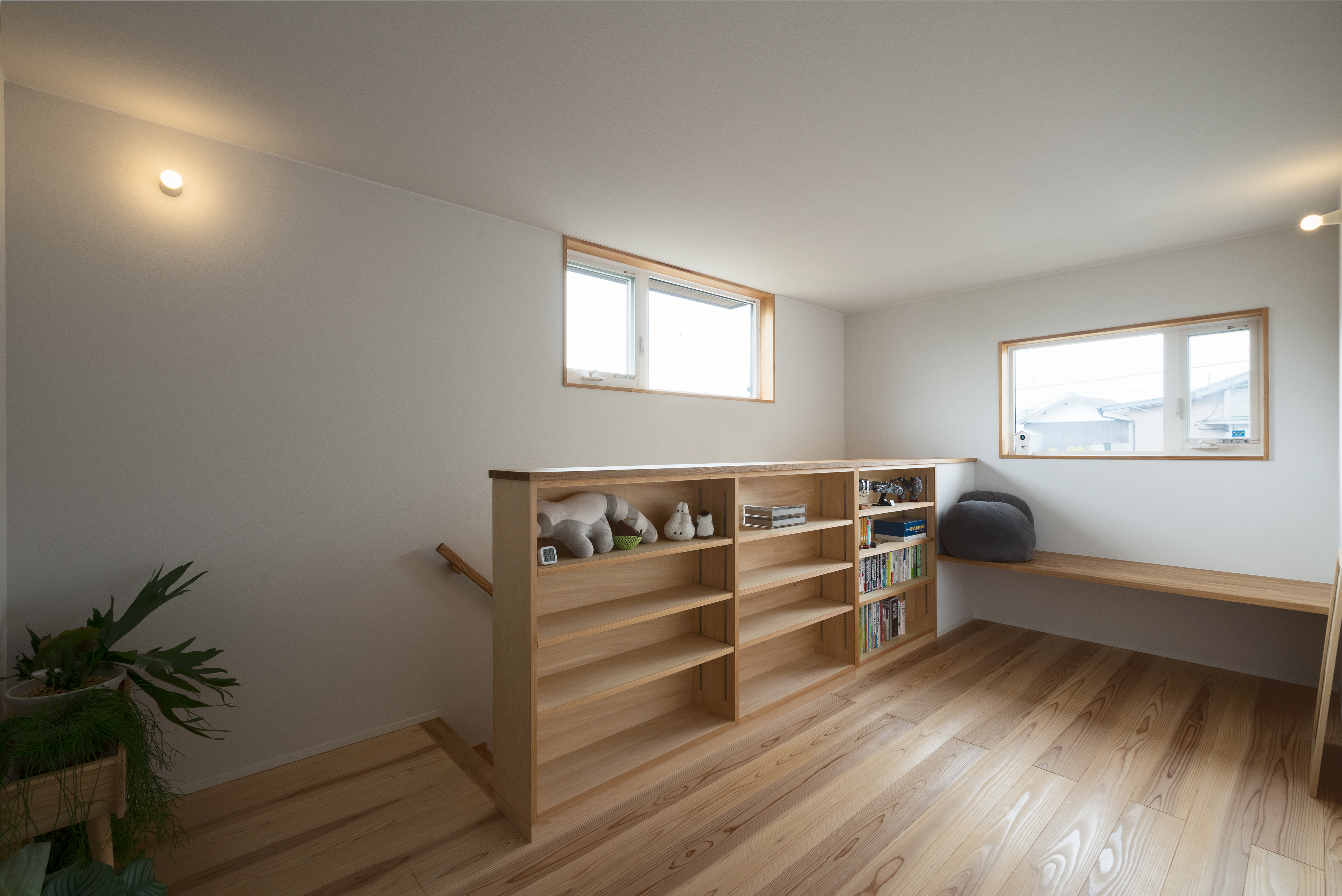 仲田工務店｜階段ホールの一角に設けた造作本棚とベンチで、静かに過ごせるフリースペースをつくりました。窓からやさしい自然光が入り、木のぬくもりに包まれた空間は、お子さまの学びや遊び、大人のくつろぎの時間にもぴったり。絵本や雑貨など、家族の「好きなもの」を自由にレイアウトできる棚が、暮らしの彩りを添えます。