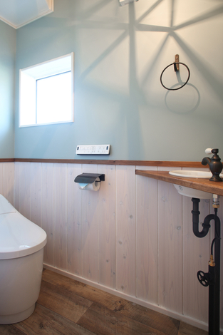 トイレは奥様こだわりのロイヤルブルーの壁紙やペンダントライトでぬくもり感あふれる空間に