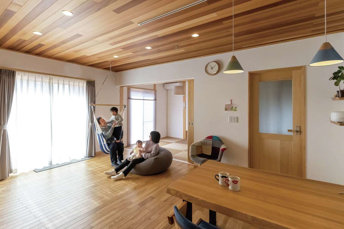 深見工務店 S-style【子育て、自然素材、間取り】ダイニングから、キッチン、リビング、和室、ウッドデッキまで見渡すことができる。リビングと和室は、段差がなくフラットにつながっているので、小さな子どもでも安心して出入り可能だ