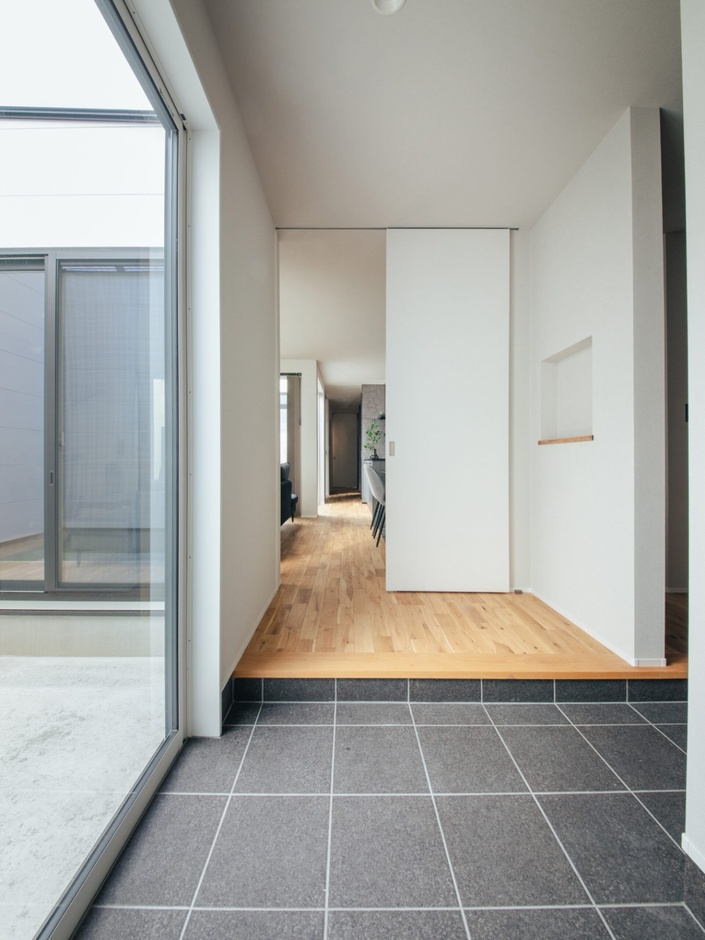 玄関土間から中庭へと視線が抜ける、開放的な玄関ホール