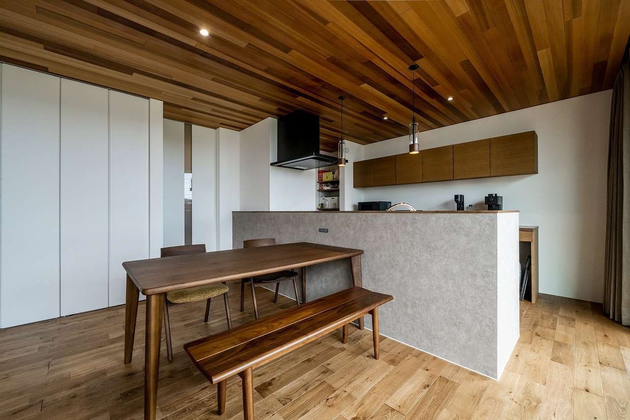アーキテックス【デザイン住宅、省エネ、平屋】床と天井の色、質感に合わせて選んだダイニングテーブルと椅子。存在感が出るペンダントライトはつけず、シンプルなダウンライトを採用した