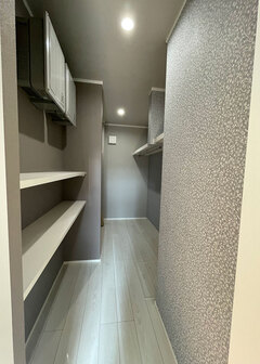 グレー系でまとめた大容量のファミリークローゼット。入口側の壁にはアクセントクロスで変化をつけた