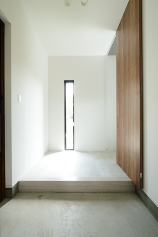 シンプルを極めた意匠が印象的なゲスト用の玄関。家族専用の玄関＆シューズクロークは別に設け、そこから裏廊下を通ってLDKにたどり着くようになっている。ゲスト用とは別ルートの動線を設けたことで、玄関を常に美しく整然と保つことができる