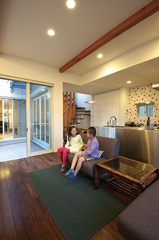 中庭の存在が明るい広がりある空間を演出するリビング。スケルトンの階段や壁紙、キッチンのデザインタイルにも施主さんのセンスの良さが伺える