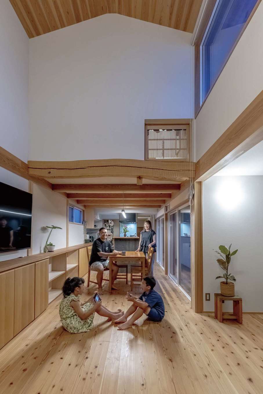 石牧建築【趣味、自然素材、省エネ】隣家が近いので、吹き抜けと中庭から光を招く設計を施した。細長い土地形状にキッチンの向きを合わせて家事効率を高めている。床は天然乾燥の天竜杉で、経年変化も楽しめる