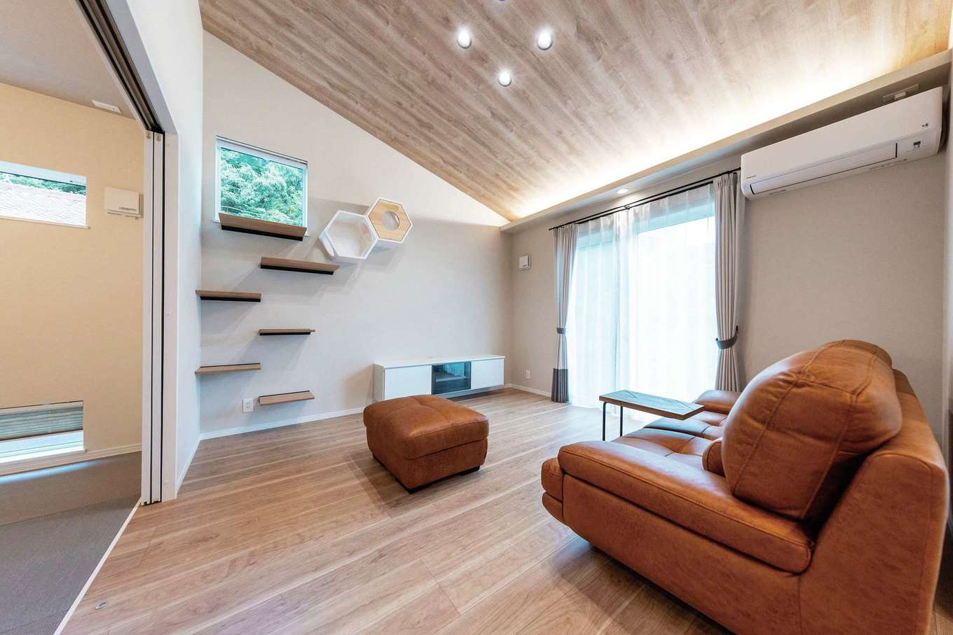 渡辺建設【省エネ、ペット、平屋】勾配天井が開放感をもたらすリビング。パナソニックの耐震住宅工法「テクノストラクチャー」が、耐震強度を担保しながら自由度の高い広々空間を叶えている。断熱性能もHEAT20 G2レベルのUA値0.41を実現。リズミカルに続く壁のキャットウォークも彩りに