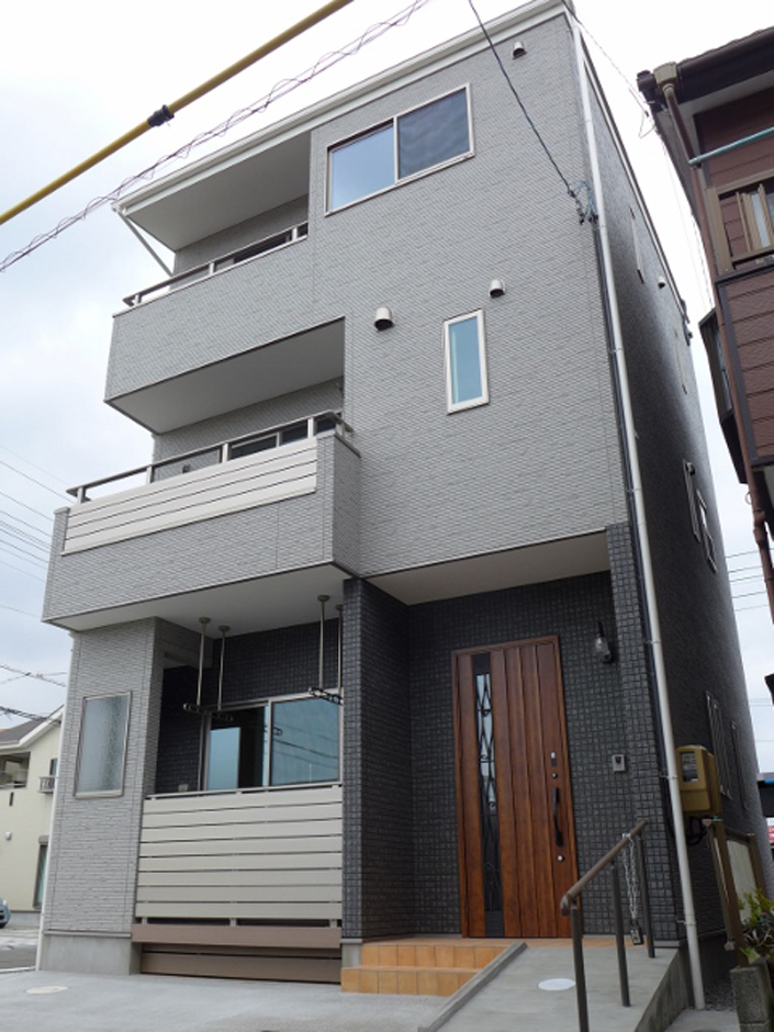 建築システム（狭小住宅専門店）【1000万円台、二世帯住宅、狭小住宅】玄関周りと西側の縦スリットをダーク系のキュービック柄にして風格と重厚感が醸し出ている