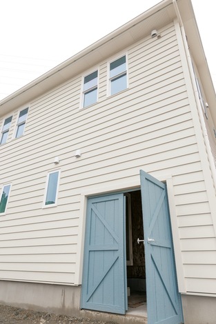 ご主人の長年の夢を叶えたビルトインのバイクガレージ。扉の色は飾り雨戸と揃えた