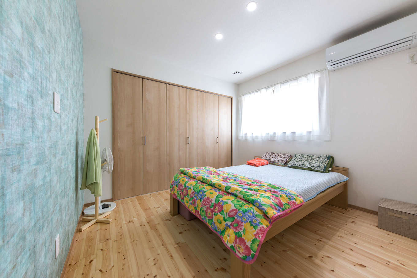 建築システム（狭小住宅専門店）【1000万円台、自然素材、平屋】壁の一面をクローゼットしてシンプルにまとめた寝室。ブルー系のアクセントクロスが爽やか