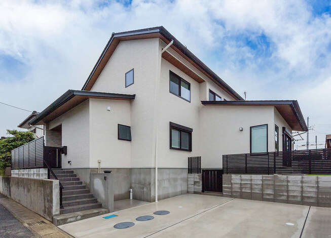 しっかりと軒を出した、シンプルで飽きのこない外観デザイン。和モダンスタイルの室内とのギャップに誰もが驚く。高低差を活かして、駐車場も3台分確保できた