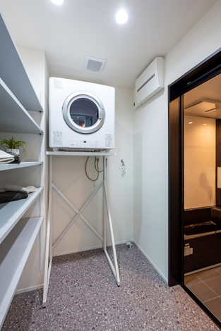 コンパクトながら機能的なランドリールーム。洗濯機が効率的に配置され、使いやすさが考慮された設計である。