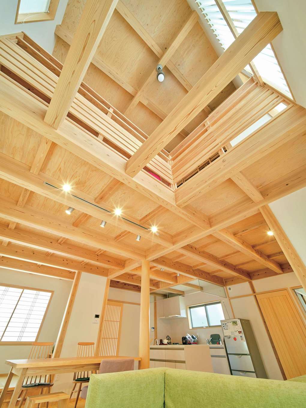 アクトホーム【自然素材、省エネ、間取り】吹き抜けのある明るい大空間リビングは採光と風の流れも丁寧に計画されている。建具も職人の手仕事