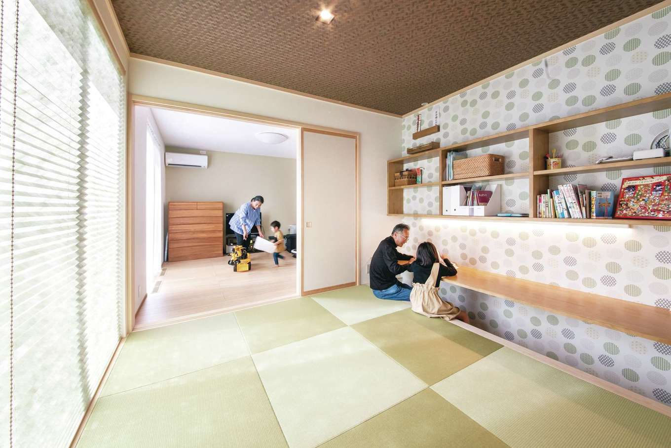 コットンハウス【子育て、二世帯住宅、省エネ】両親の部屋とLDKの間につくった和室は二世帯の共有スペース。今日はジイジが絵本の読み聞かせ