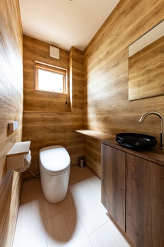 広めに作られたトイレは手洗い器とカウンター付き。木目調の壁紙で仕上げており、落ち着いた時間が過ごせる。