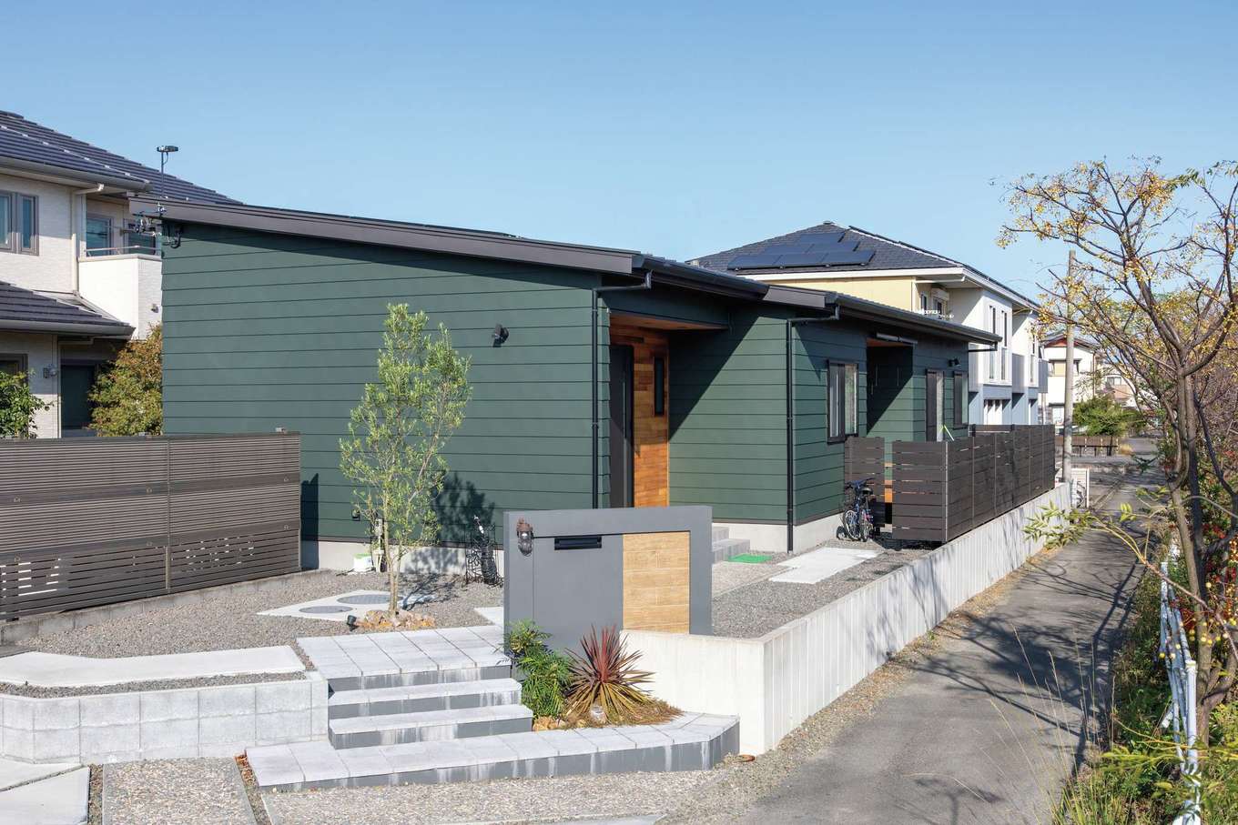 KUREKEN HAUS（榑林建設）【デザイン住宅、省エネ、間取り】外観はガルバリウム鋼板の横葺きで、長い面もつなぎ目がないよう一枚板で仕上げてもらった。玄関回りのレッドシダーがアクセント。屋根には13.5kWもの太陽光パネルが搭載された