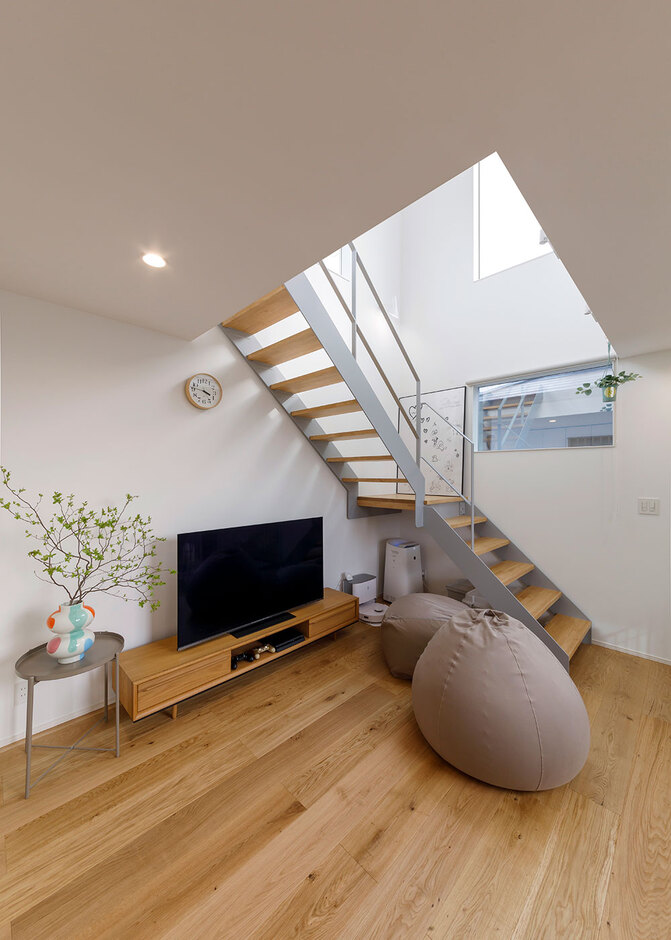 目線が上へと抜けていく吹抜けのリビング。スケルトンの階段をグレーにしたことで空間に統一感が生まれた。ナチュラルテイストの無垢フローリングは『nattoku住宅』オリジナルで、時とともに味わいを深めていく
