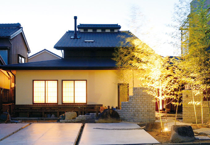 竹林が彩る石畳のアプローチ。わざと起伏を付けることで実際以上の奥行き感を演出。エアパス工法の特徴でもある腰屋根がアクセントに