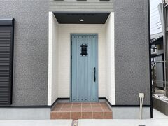 青い玄関ドアが目を引くスタイリッシュな住まい