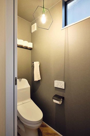 床はヘリンボーン柄のフロアタイル。壁・天井はグレーのアクセントクロスで仕上げた