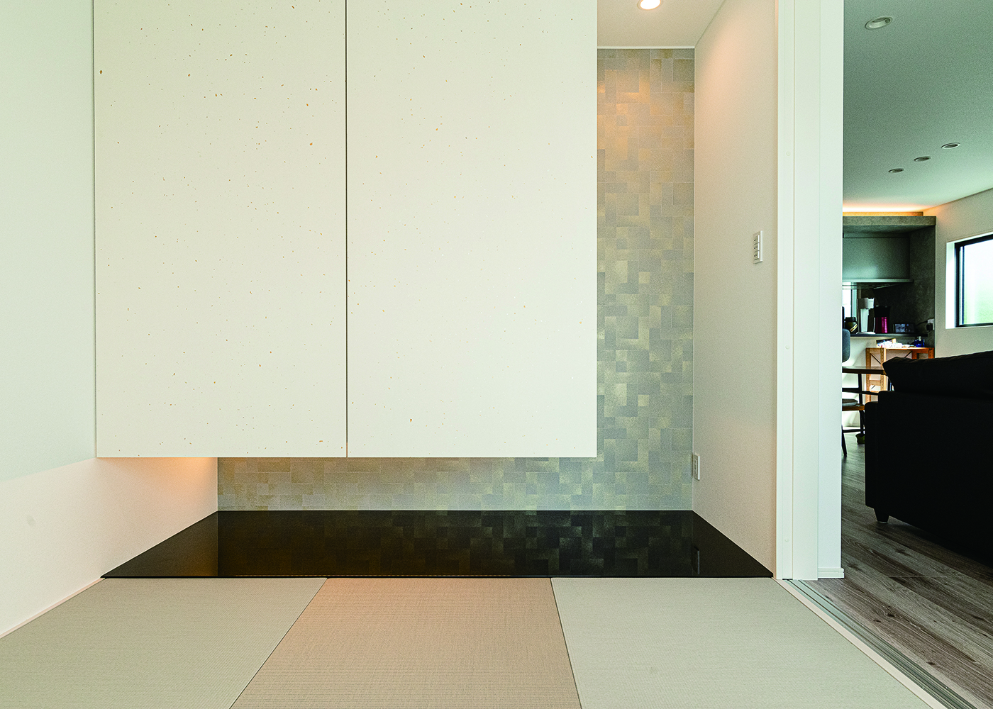 HAPPY HOUSE（山田工務店）【子育て、間取り、屋上バルコニー】LDKの雰囲気に合わせて、モダンに仕上げた和室。壁のクロスや床板の素材なども、提案を受けながら丁寧に吟味した。吊った収納の下部は、季節人形の置き場などに活用