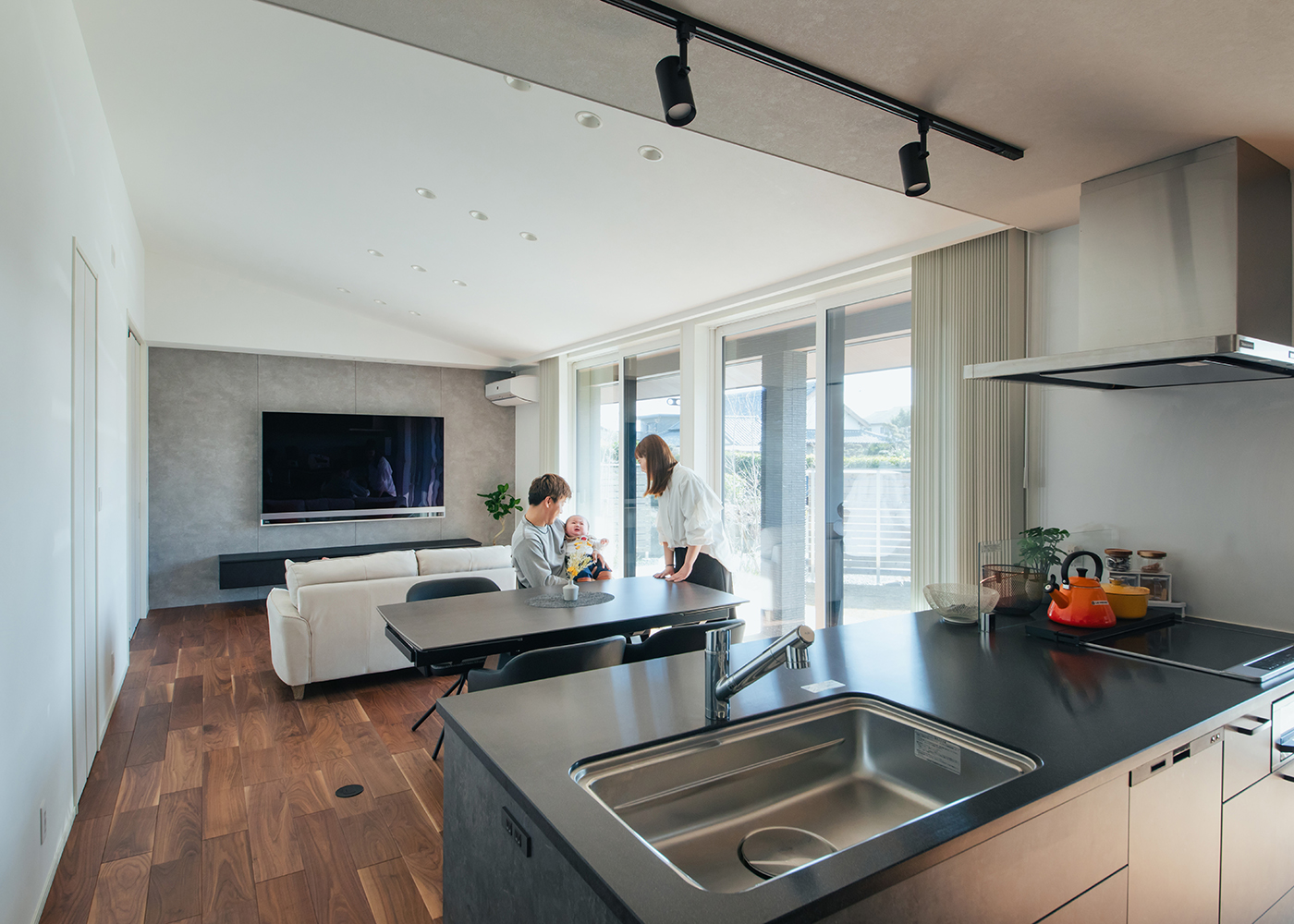 アイ工務店【子育て、間取り、平屋】77インチのテレビ、庭の景色が見える位置にキッチンを配置。勾配天井を採用したことで、より広く感じられる