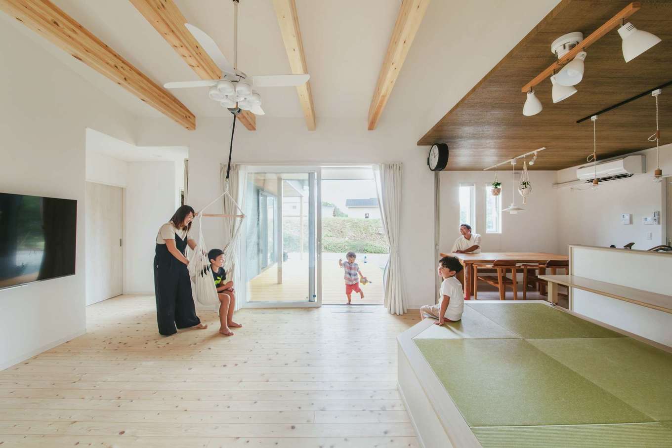 子育て安心住宅 Design Craft Office【デザイン住宅、子育て、平屋】ヒノキの床が広がる勾配天井のリビング。梁に吊るしたハンモックは長男の指定席。TVを掛けた壁裏にウォークスルー型の収納を確保