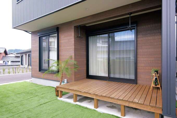 リビングから続くウッドデッキを設け、庭には人工芝を敷いた